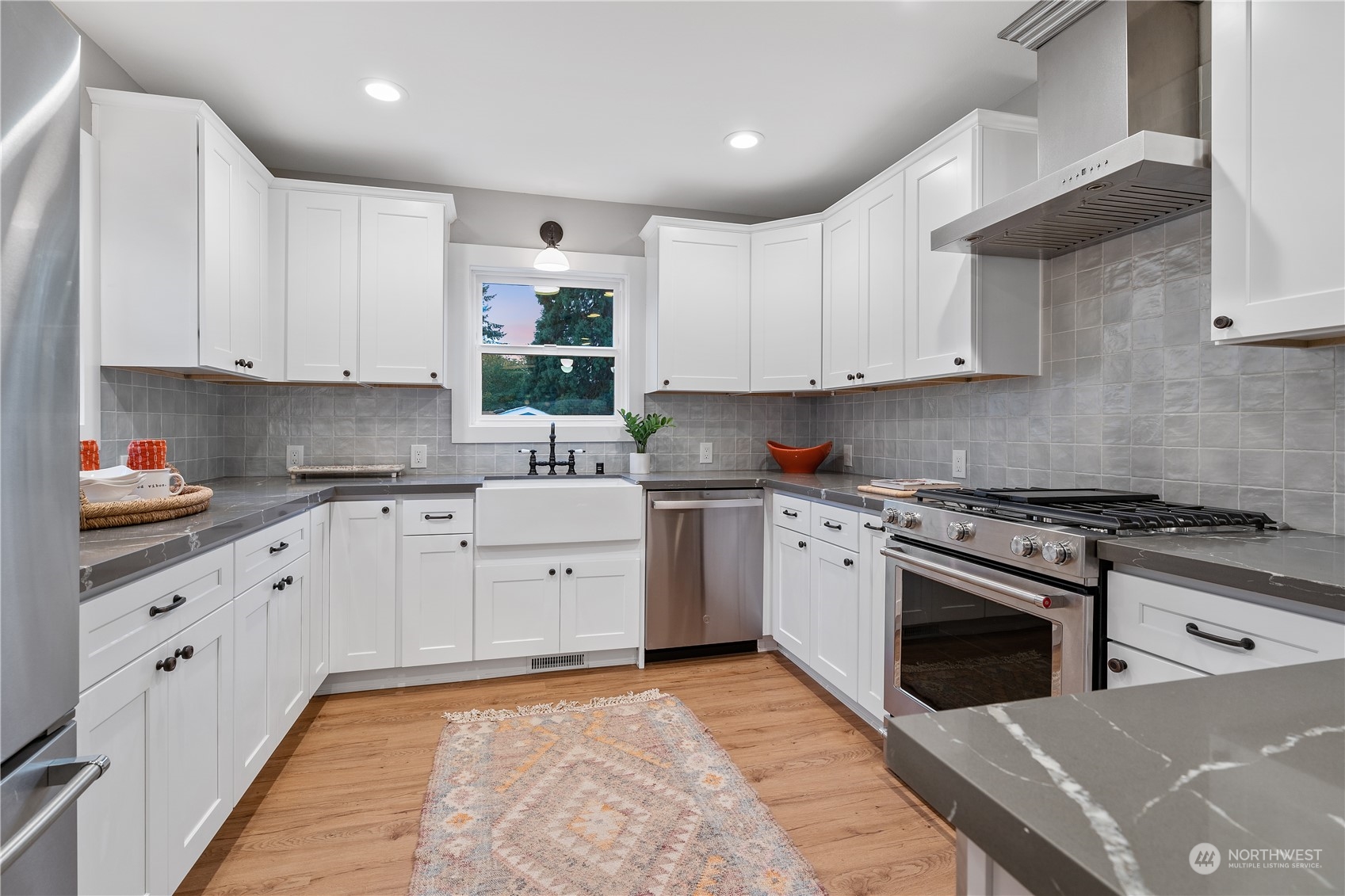 3541 Southwest 100th Street Seattle, WA 98146 - Photo 6 of 25 a kitchen with stainless steel appliances granite countertop a stove and white cabinets