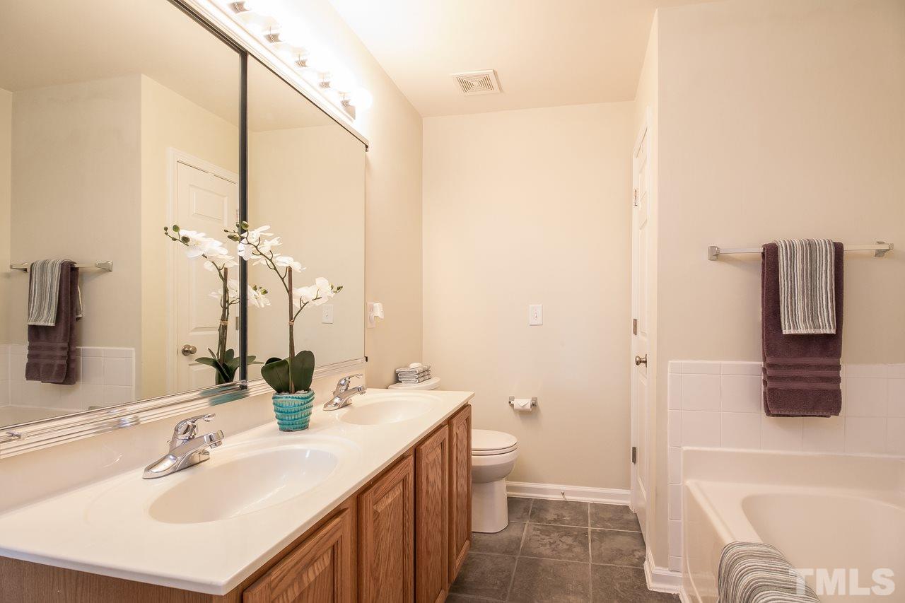 11701 Coppergate Drive, Unit 105 Raleigh, NC 27614 - Photo 21 of 25 Cultured marble topped double vanity with a large mirror/medicine cabinet provide plenty of storage space. Also features a tile floor and a linen closet.