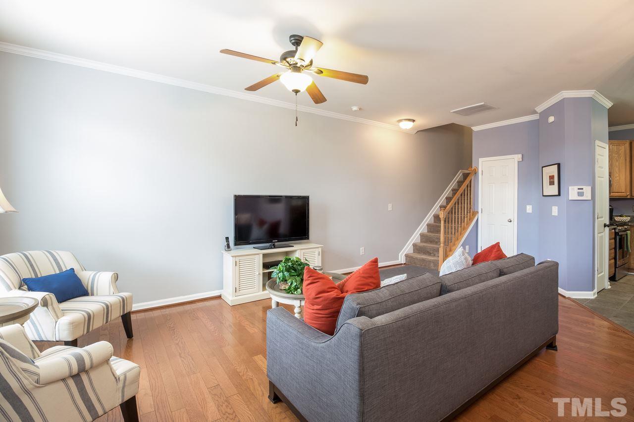 11701 Coppergate Drive, Unit 105 Raleigh, NC 27614 - Photo 5 of 25 Another view of the living room showing the stairs to the second floor and the ceiling fan. Door to the right of stairs is a huge closet for coats with additional storage under the stairs.