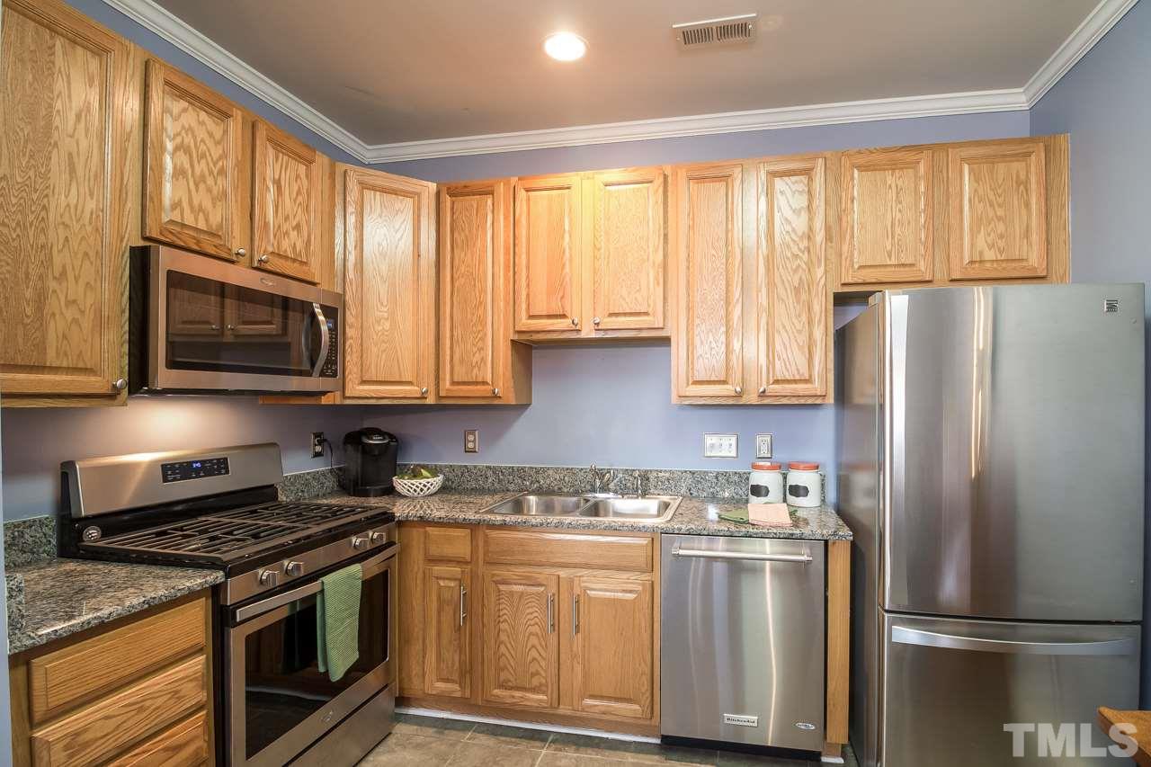 11701 Coppergate Drive, Unit 105 Raleigh, NC 27614 - Photo 9 of 25 Recently updated - granite counters and stainless appliances including a gas range, microwave, dishwasher and refrigerator. The kitchen also features a double sink with disposal.