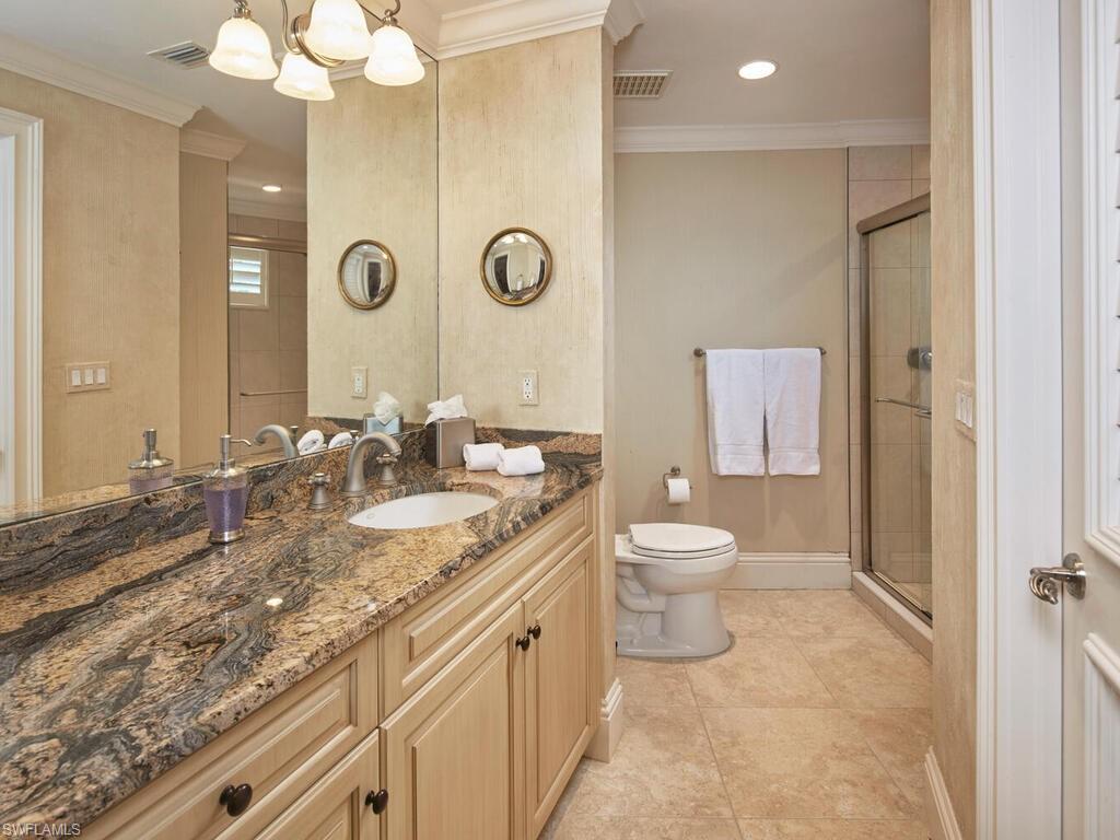 377 Pirates Bight Naples, FL 34103 - Photo 37 of 44 a bathroom with a granite countertop sink a toilet and a mirror
