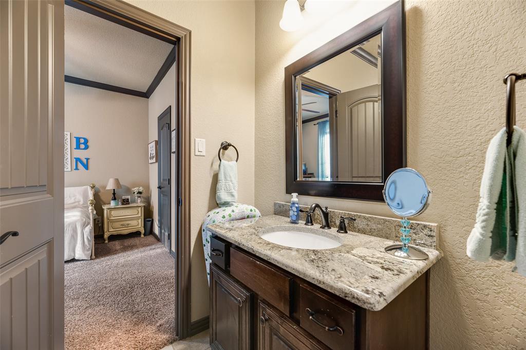 1132 Chartres Street Kaufman, TX 75142 - Photo 18 of 25 Bathroom vanity featuring a light-toned granite countertop, undermount sink, and dark bronze-finish fixtures