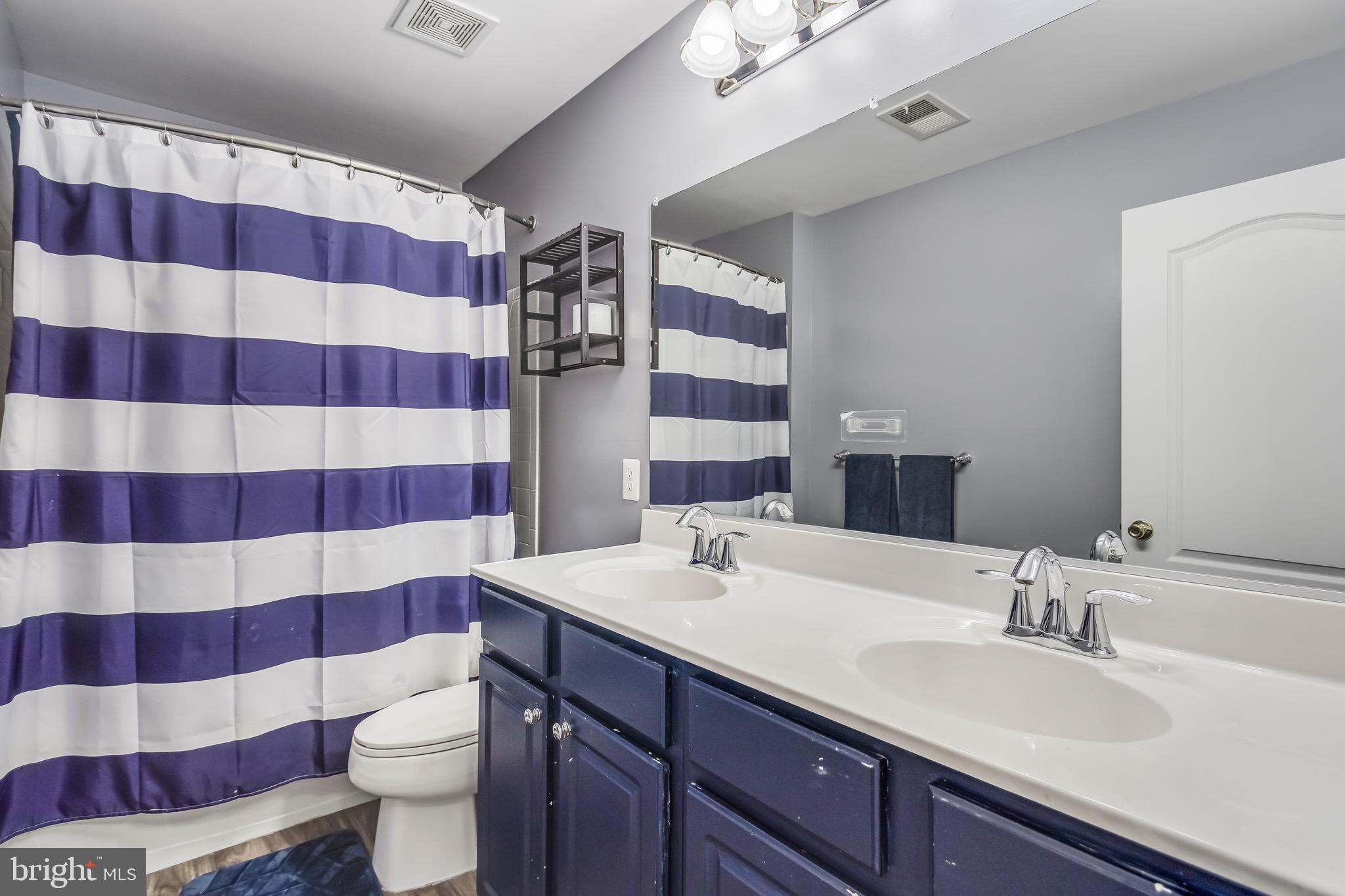 16607 Mannington Road Accokeek, MD 20607 - Photo 21 of 32 a bathroom with a sink toilet a shower and a mirror