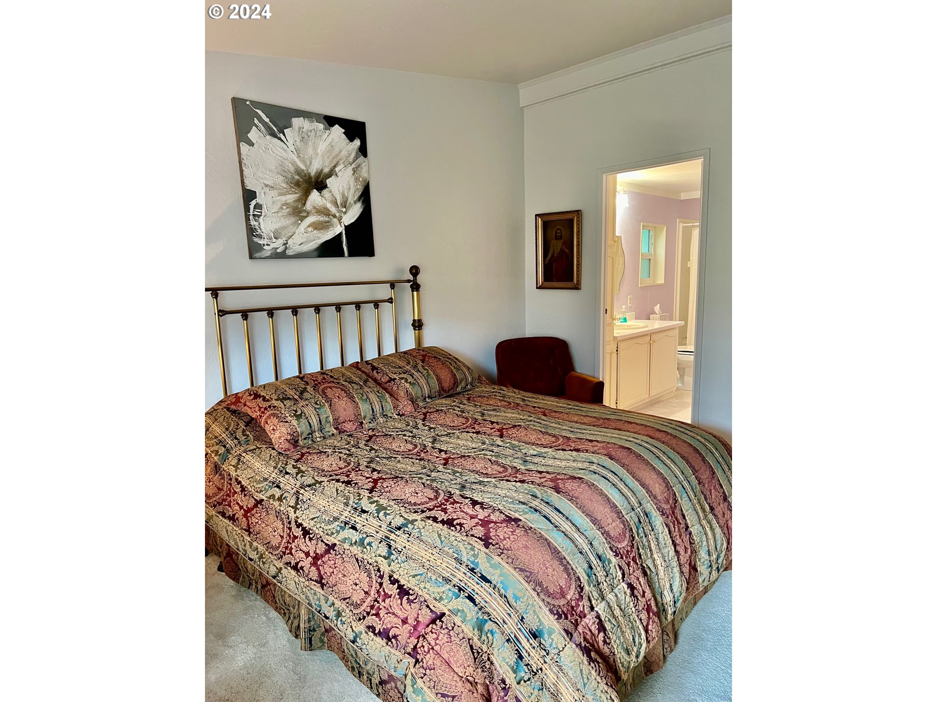 1601 Rhododendron Drive, Unit 694 Florence, OR 97439 - Photo 12 of 32 a bedroom with a bed and painting on the wall