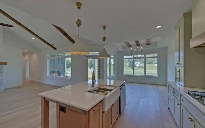 317 Bell Creek Cove Road Hiawassee, GA 30546 - Photo 13 of 74 a kitchen with a stove a sink a refrigerator dining table and chairs