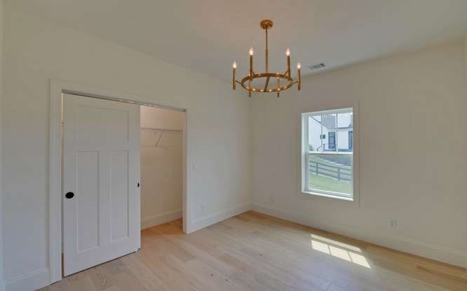 317 Bell Creek Cove Road Hiawassee, GA 30546 - Photo 36 of 74 an empty room with windows and chandelier fan