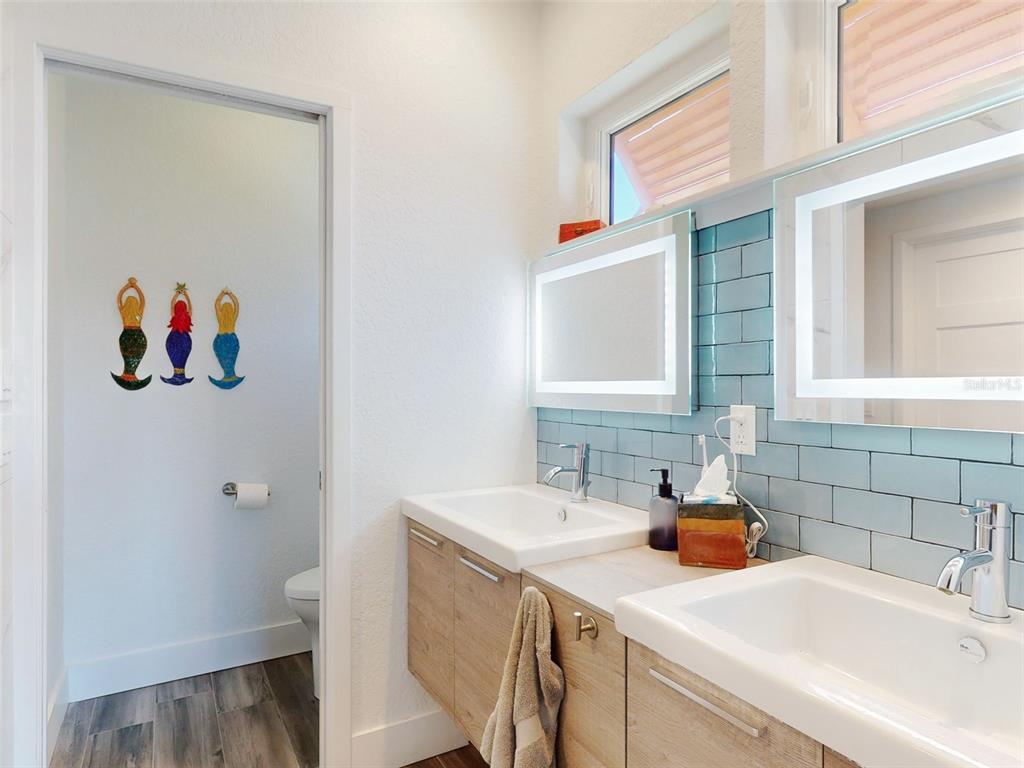901 Sheepshead Avenue New Smyrna Beach, FL 32169 - Photo 19 of 64 a bathroom with a sink and a painting on the wall