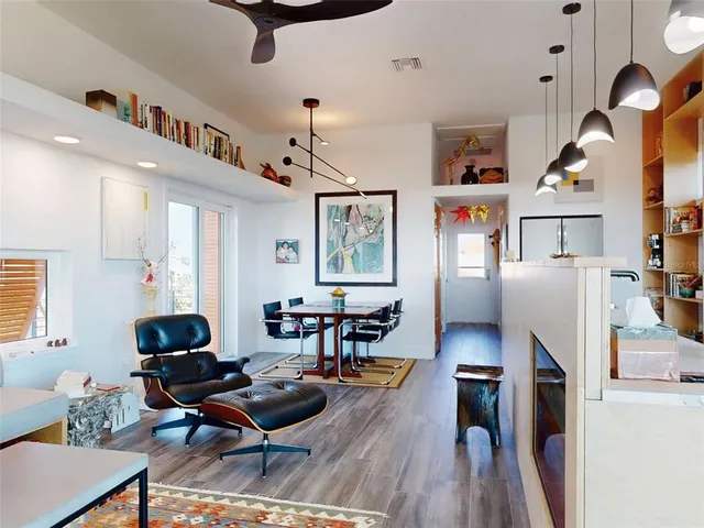a living room with furniture kitchen view and wooden floor