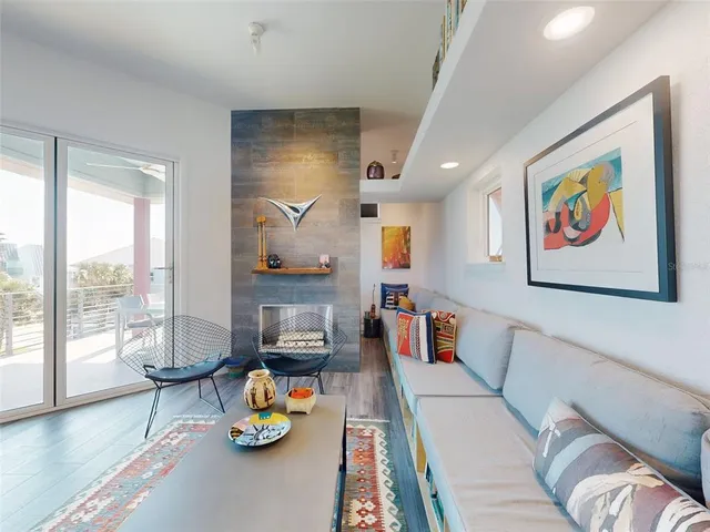 a living room with furniture kitchen view and a wooden floor