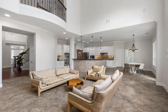 a living room with furniture and a dining table with kitchen view