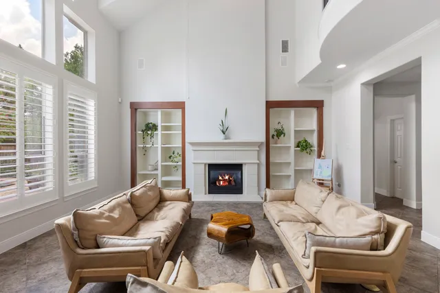 a living room with furniture a fireplace and a large window