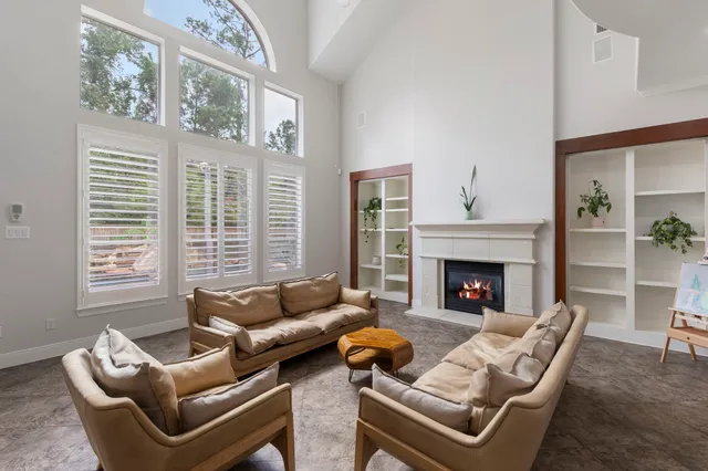 a living room with furniture a large window and a fireplace