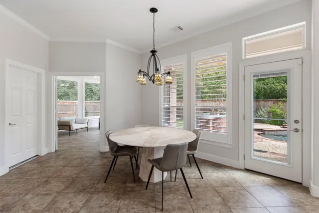 a dining room with furniture a chandelier and window