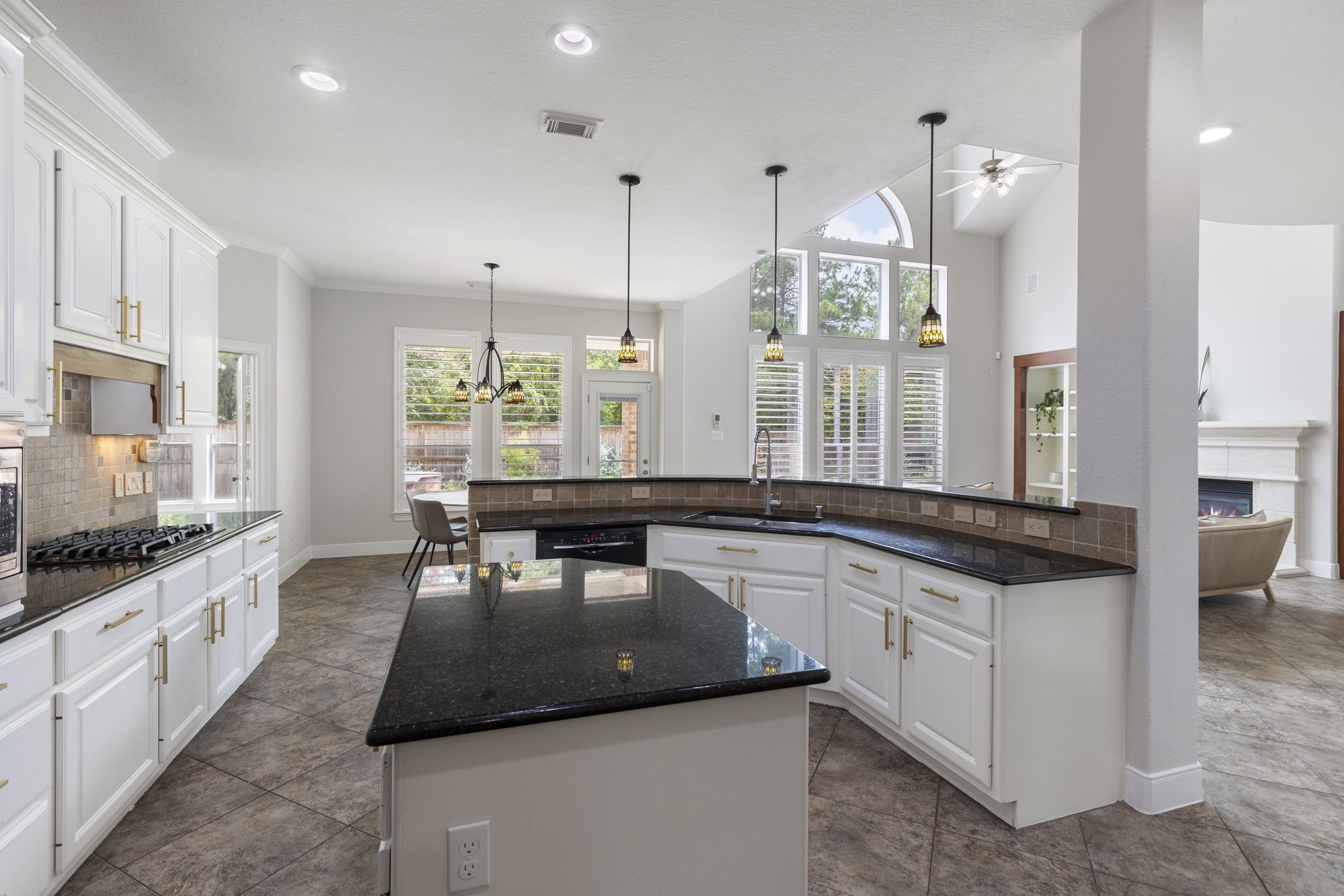 6 Skipwith Place Spring, TX 77382 - Photo 18 of 44 a large kitchen with kitchen island a large counter space a sink stainless steel appliances and windows