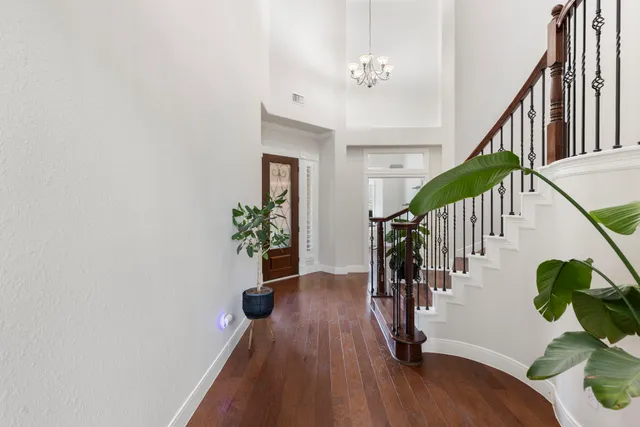 a hallway with wooden floor and stairs