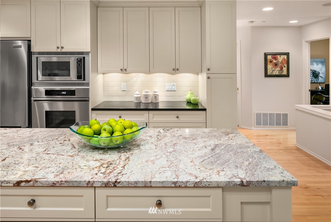 14633 Southeast 82nd Court Newcastle, WA 98059 - Photo 10 of 34 a kitchen with stainless steel appliances granite countertop a sink a stove and a wooden floors
