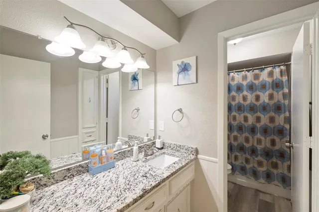 a bathroom with a granite countertop sink a large mirror and a shower
