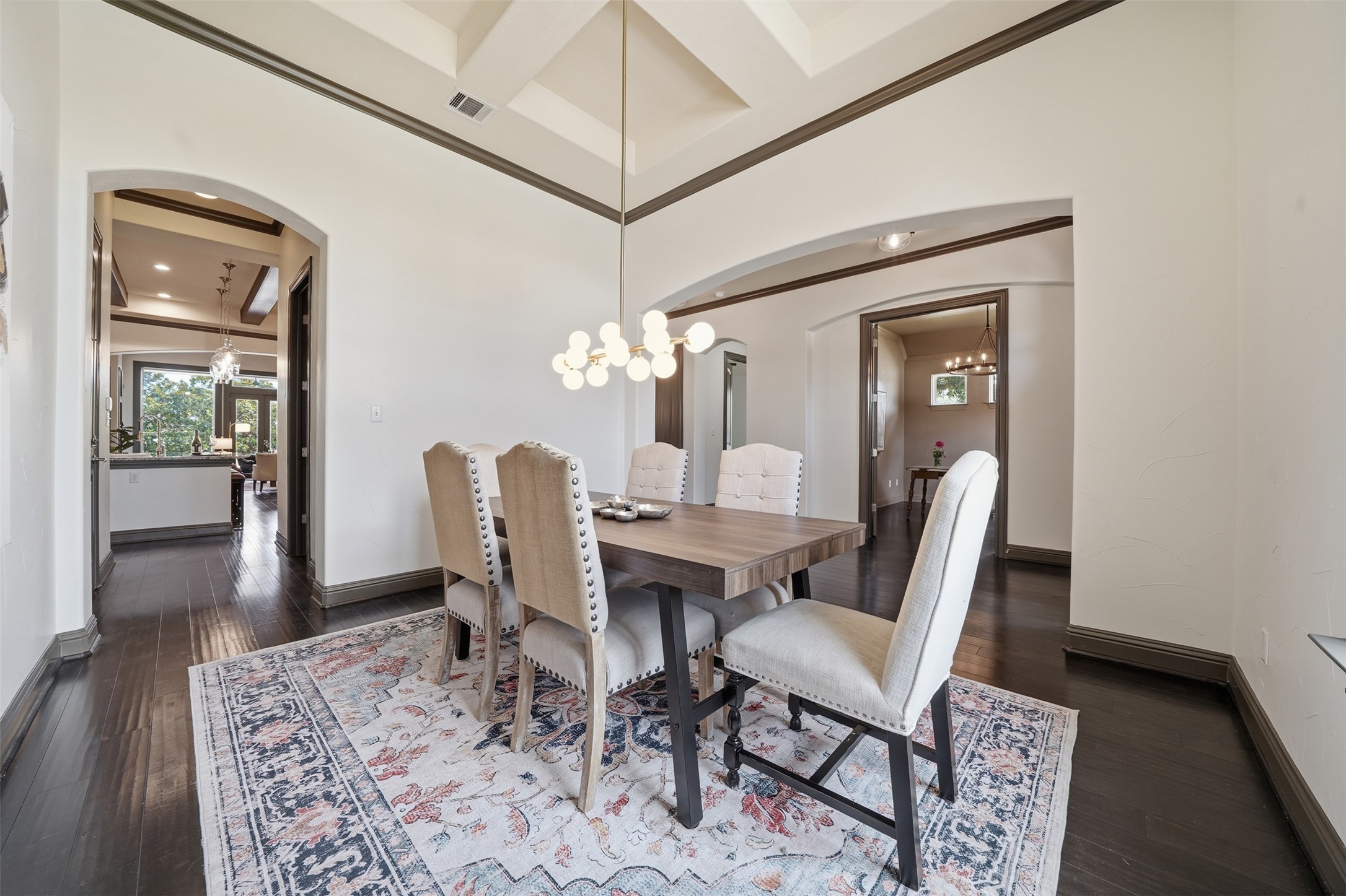 8729 Vantage Point Drive Austin, TX 78737 - Photo 7 of 33 A designer light fixture illuminates the elegant dining area with dark hardwood floors and an arched entryway.