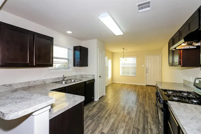 a kitchen with stainless steel appliances granite countertop a sink stove and refrigerator