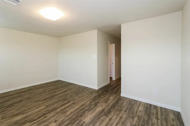 a view of an empty room with wooden floor