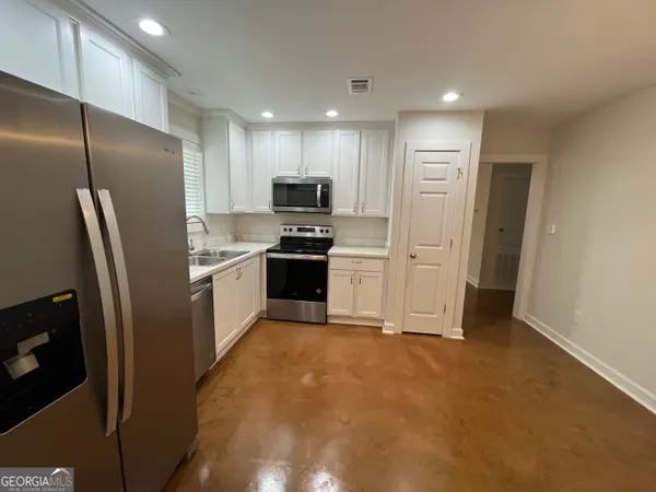 a kitchen with stainless steel appliances granite countertop a refrigerator a stove and a sink