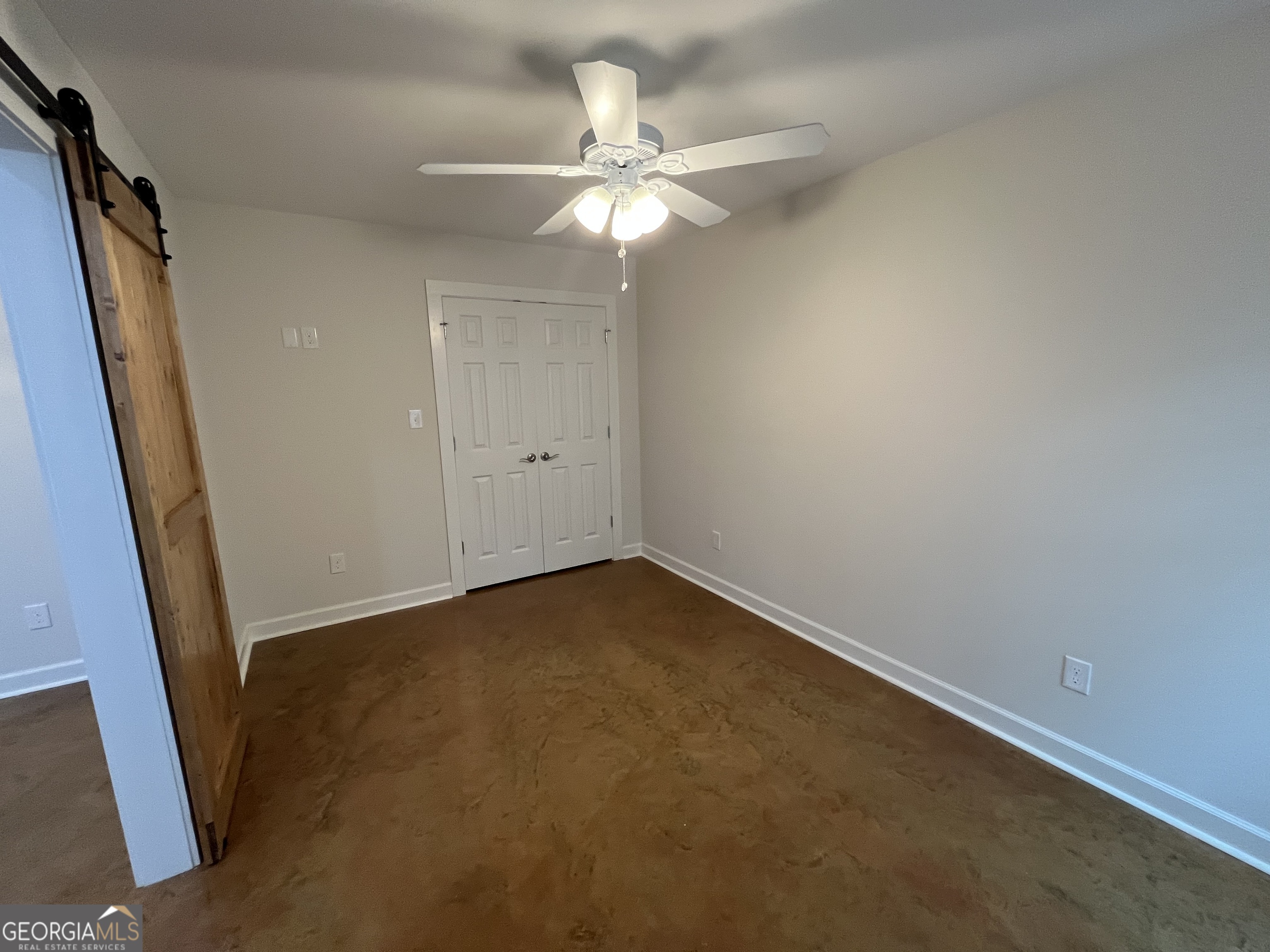 1112 3rd Street, Unit B Perry, GA 31069 - Photo 5 of 11 an empty room with a ceiling fan and window