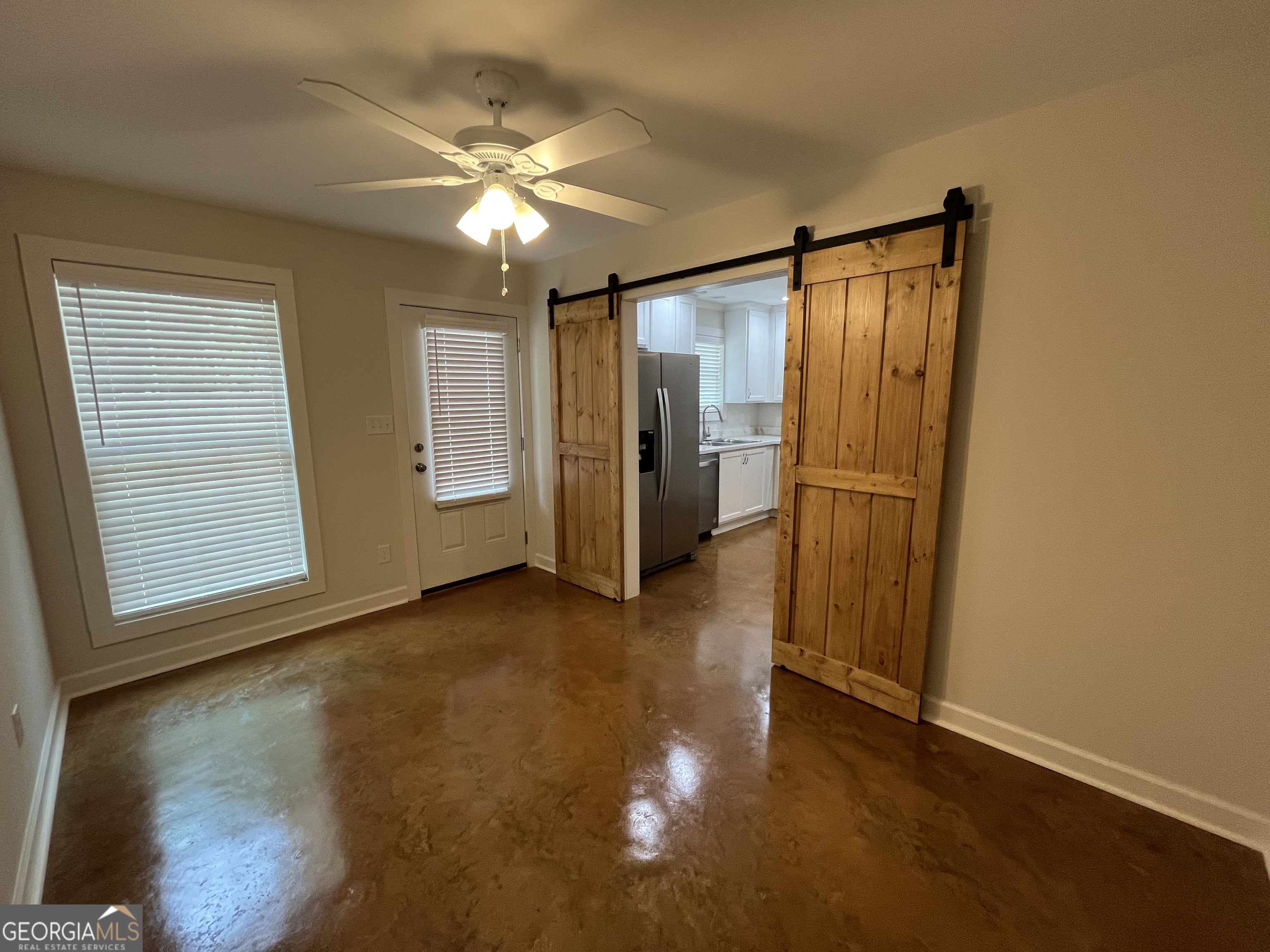 1112 3rd Street, Unit B Perry, GA 31069 - Photo 6 of 11 an empty room with wooden floor cabinet and windows