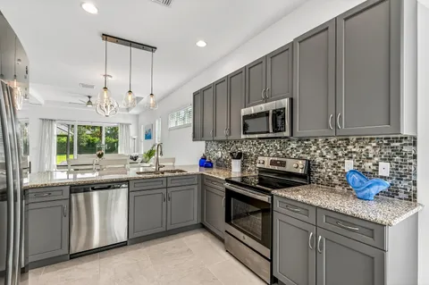 a kitchen with stainless steel appliances a sink stove and microwave