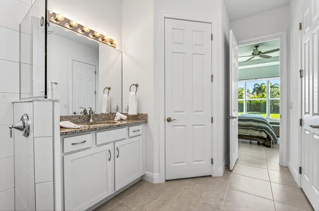 a bathroom with a granite countertop sink and a mirror