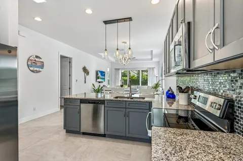 a kitchen with stainless steel appliances a sink stove and cabinets