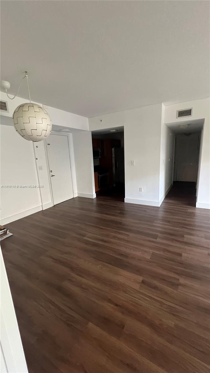 2775 Northeast 187th Street, Unit 227 Aventura, FL 33180 - Photo 13 of 17 a view of an empty room with wooden floor and a chandelier