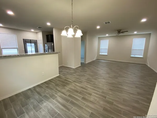 a view of a room with wooden floor and a ceiling fan