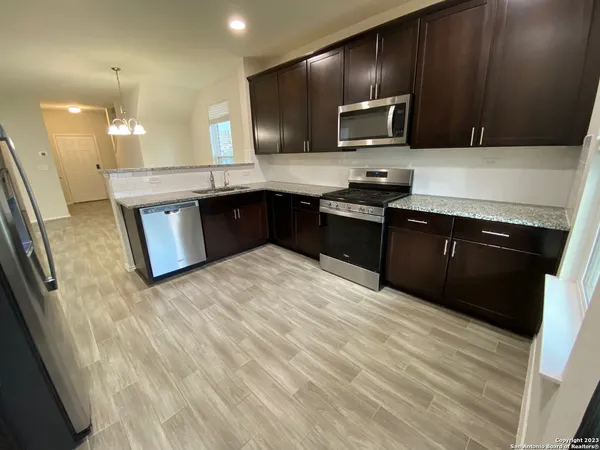 a kitchen with stainless steel appliances granite countertop a stove a sink and a microwave