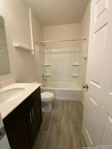 a bathroom with a sink a toilet a mirror and shower