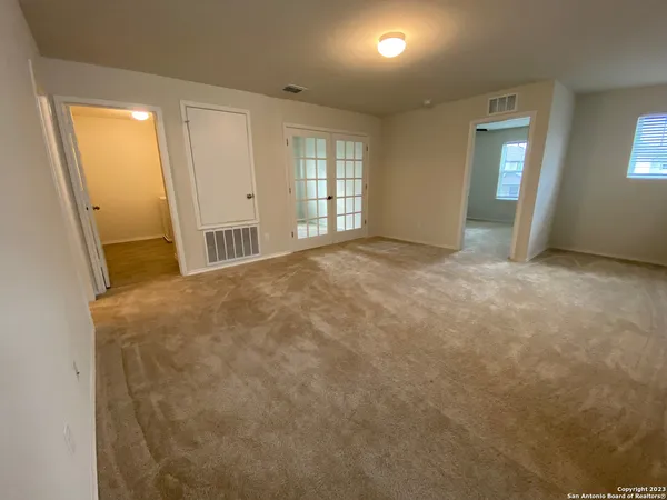 an empty room with windows and fan