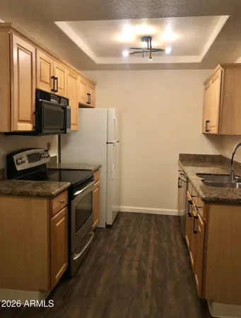 a kitchen with stainless steel appliances granite countertop a stove a sink and a refrigerator