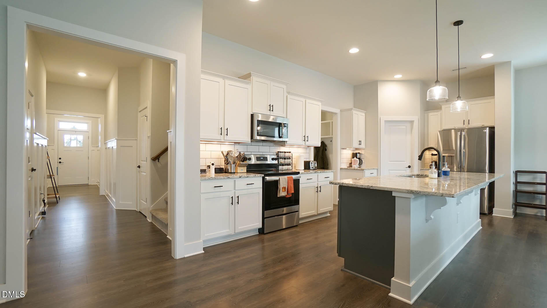 693 South Wilma Street Angier, NC 27501 - Photo 3 of 51 a kitchen with stainless steel appliances kitchen island granite countertop a stove a sink a refrigerator and white cabinets with wooden floor