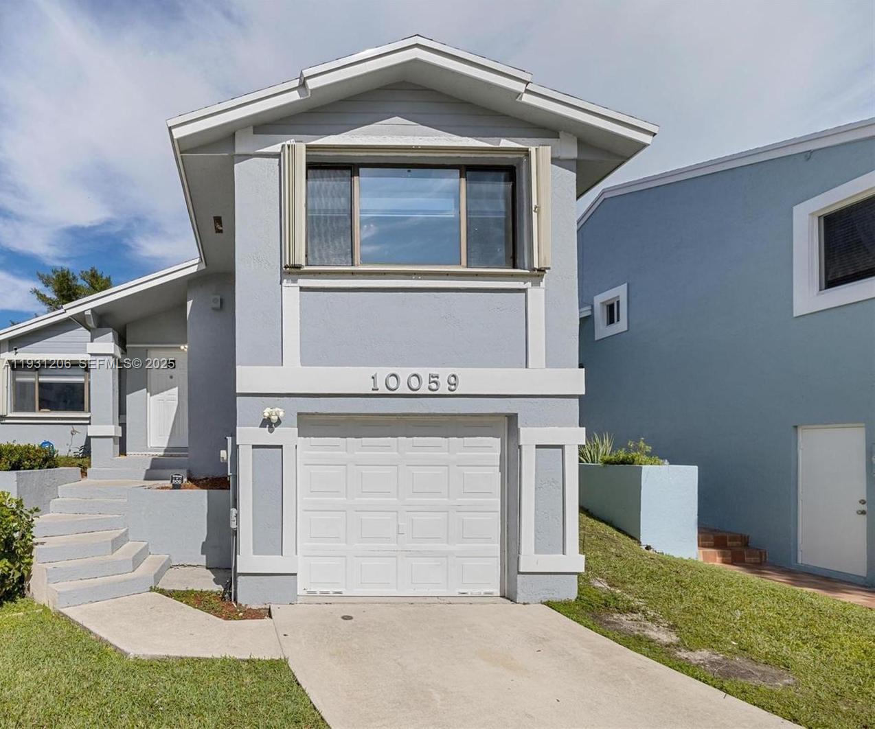 10059 Southwest 218th Street, Unit 10059 Cutler Bay, FL 33190 - Photo 12 of 15 a front view of a house with garage