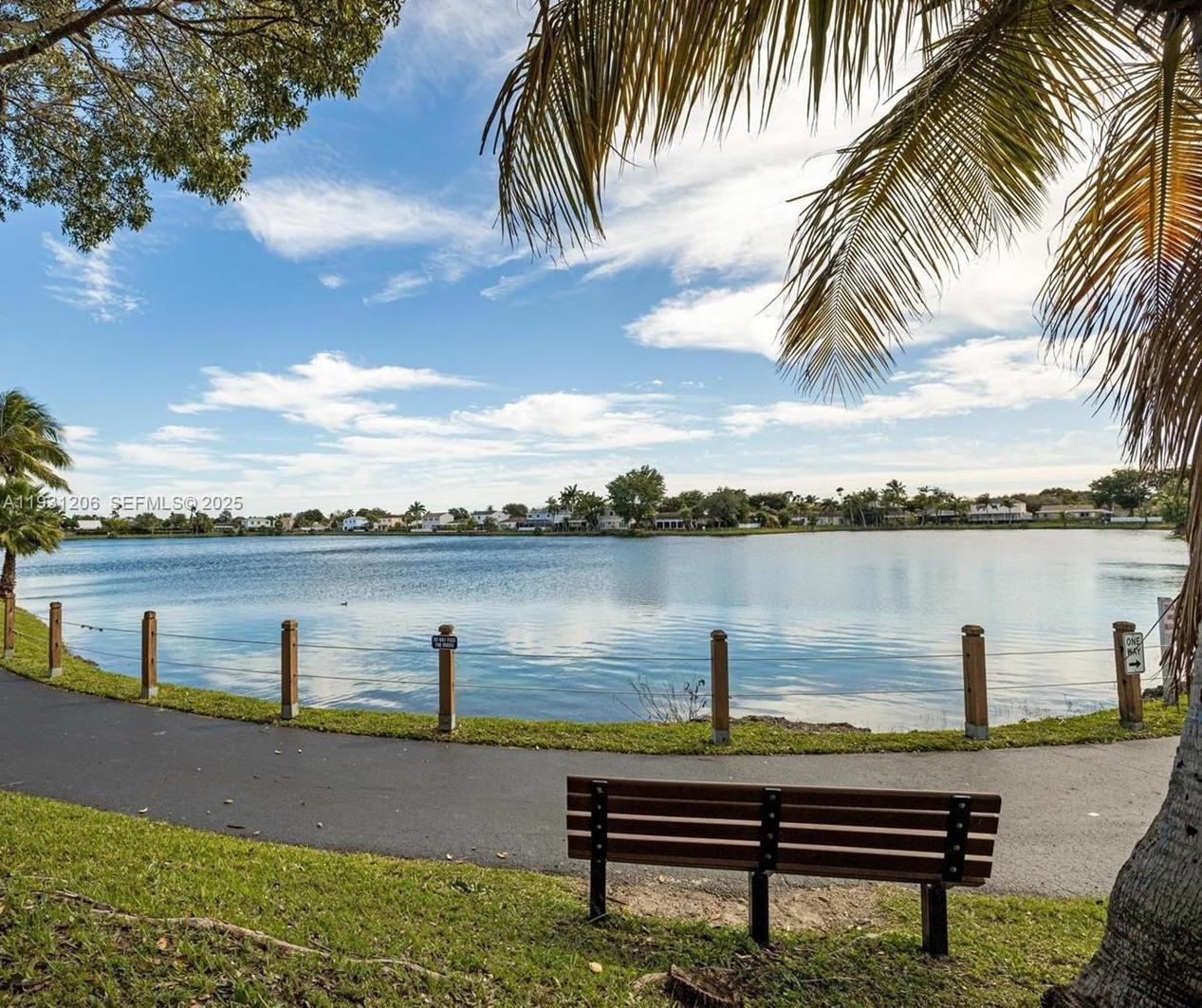 10059 Southwest 218th Street, Unit 10059 Cutler Bay, FL 33190 - Photo 14 of 15 a view of a lake with a yard and a large trees