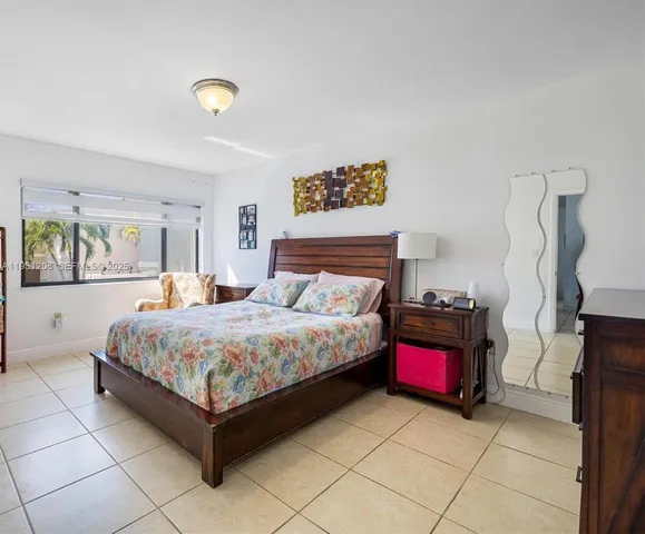 a bedroom with a bed and dresser with mirror