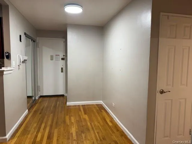 a view of a room with wooden floor and a bathroom