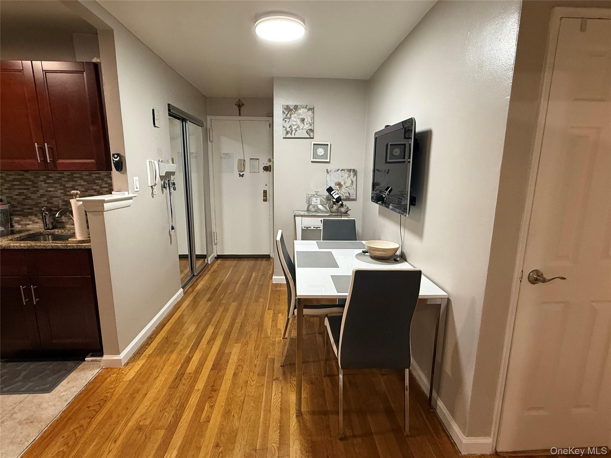 3123 Bailey Avenue, Unit 3A Bronx, NY 10463 - Photo 8 of 17 a dining room with furniture and a flat screen tv