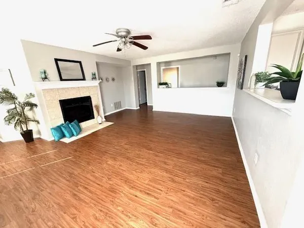 a view of empty room with wooden floor and fireplace