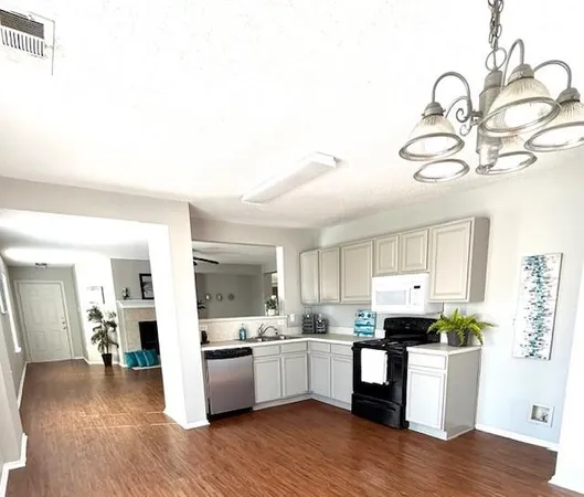 a kitchen with a sink cabinets and wooden floor