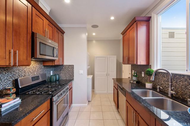 a kitchen with stainless steel appliances granite countertop a stove a sink and a microwave