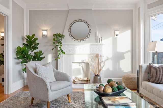 a living room with furniture a potted plant and a large window