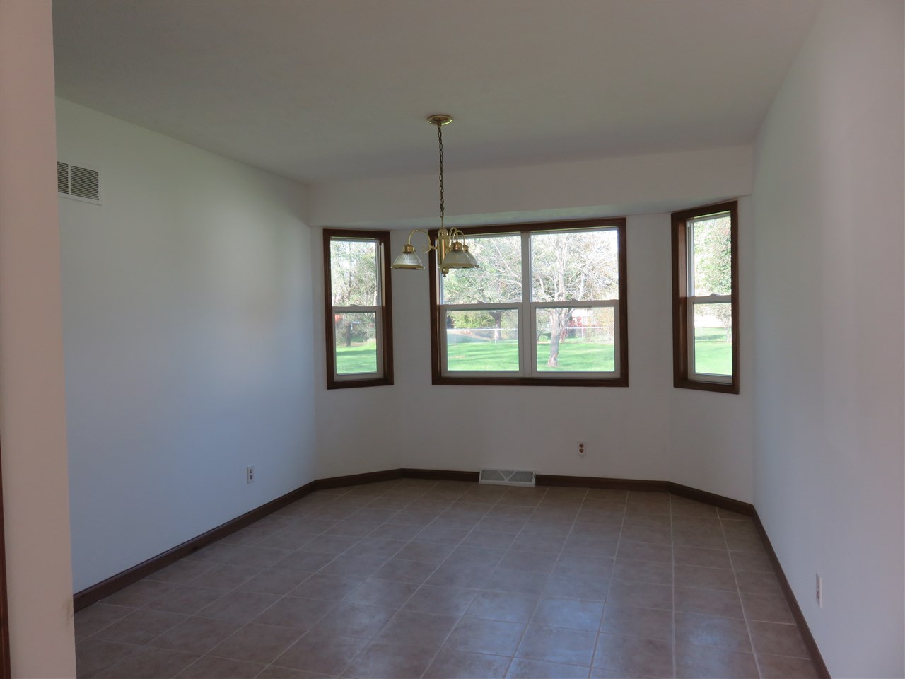 12140 Tresemer Road Roscoe, IL 61073 - Photo 5 of 17 an empty room with windows and ceiling fan