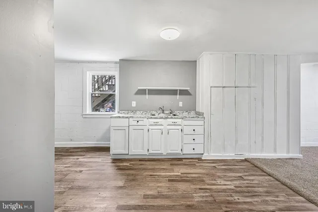 a view of kitchen with granite countertop cabinets and sink