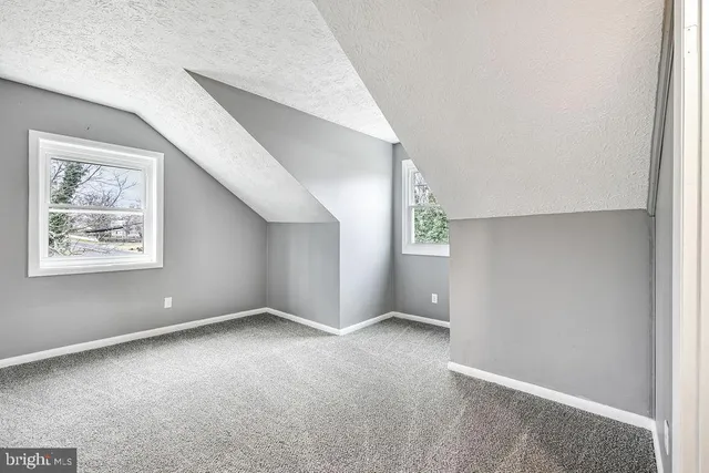 an empty room with windows and closet