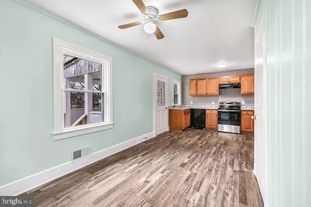 a kitchen view with wooden floor and a window